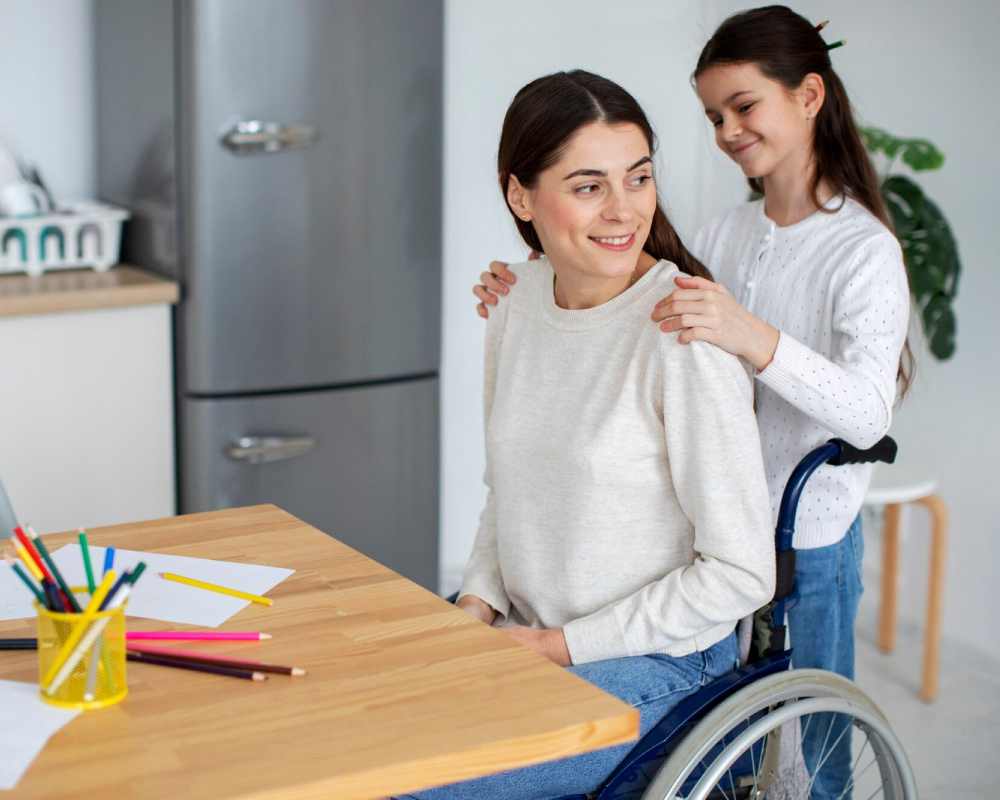 Young girl supporting her mother in a wheelchair at home while spending quality time together at the table
